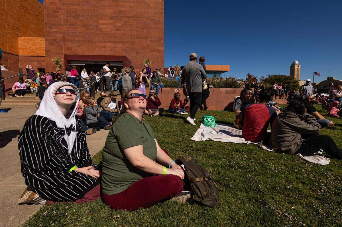 Amber and Lilly Plott, 11, look up at the solar eclipse with other spectators during the Annular Solar Eclipse event at the Fort Worth Museum of Science & History on Saturday, Oct. 14, 2023.