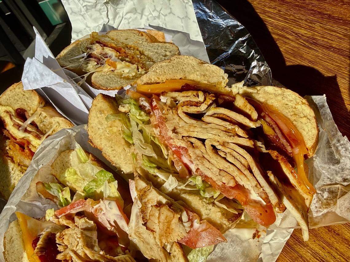 A turkey club sandwich at Shug’s Bagels with spicy Boar’s Head turkey, and a bacon-egg-and-cheese bagel in the background, as seen Nov. 7, 2025.