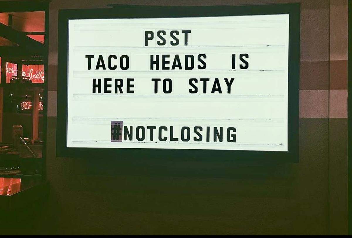 A sign outside the Montgomery Street location of Taco Heads announces that the restaurant will stay after what the owner described as a “weird situation.”