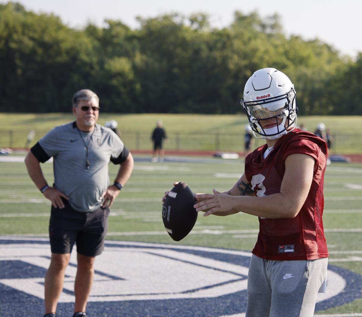 Head coach Aaron Beck watches as quarterback Gavin Beard completes a pass during the first practice of 2025 for the All Saints in Fort Worth, Texas, Tuesday August, 05, 2025.