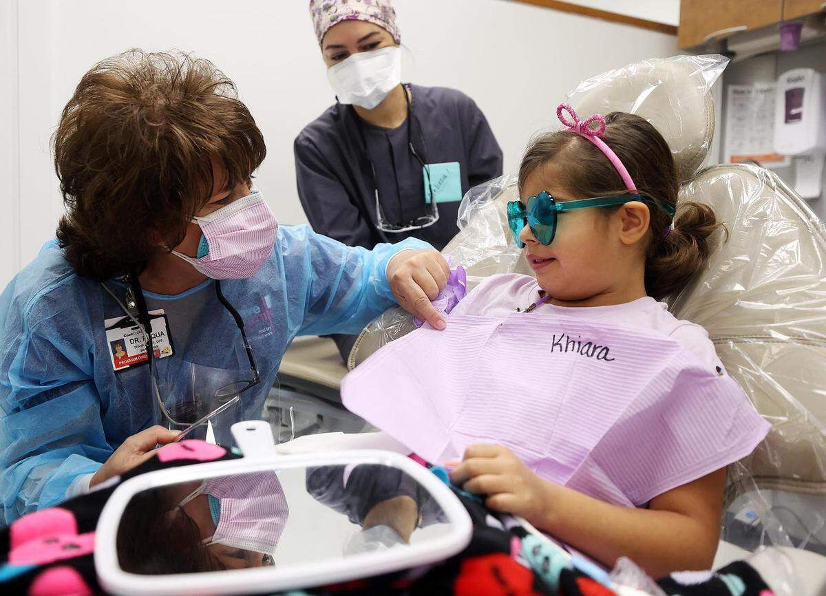 Dr. Tonya Fuqua, left, puts Khiara Gonzalez, 7, at ease while having her teeth cleaned in November. Save a Smile partnered with Tarrant Community College’s dental hygiene department to provide 19 children with no-cost preventive oral care.
