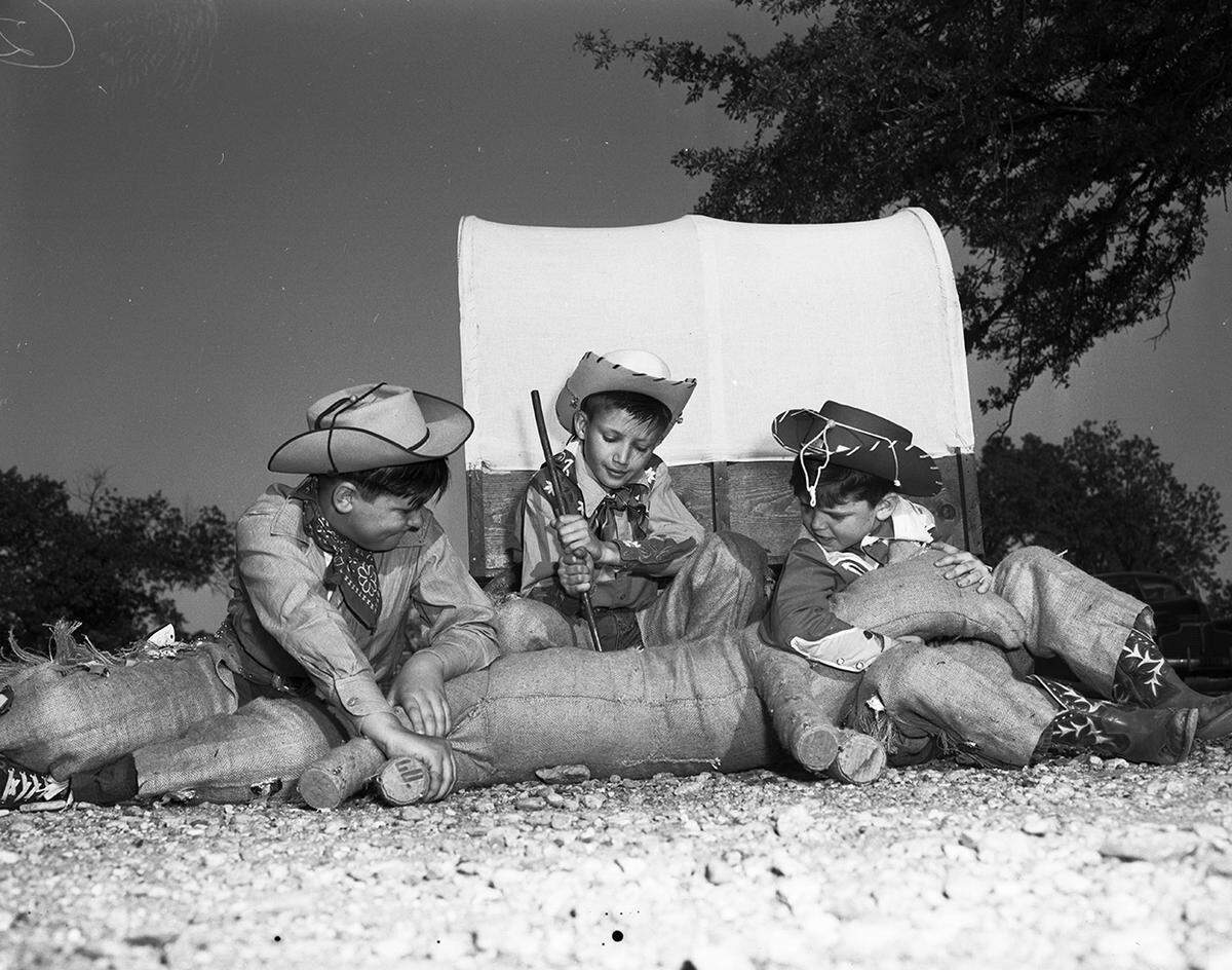 April 25, 1950: Cub Scouts in the cowboy scene of the annual Boy Scout Circus apply the branding iron to a “dogie” in front of their miniature chuck wagon. Left to right are Don Cole, Jimmy Hartman and Eddie MacConnell, all of Cub Pack 66.