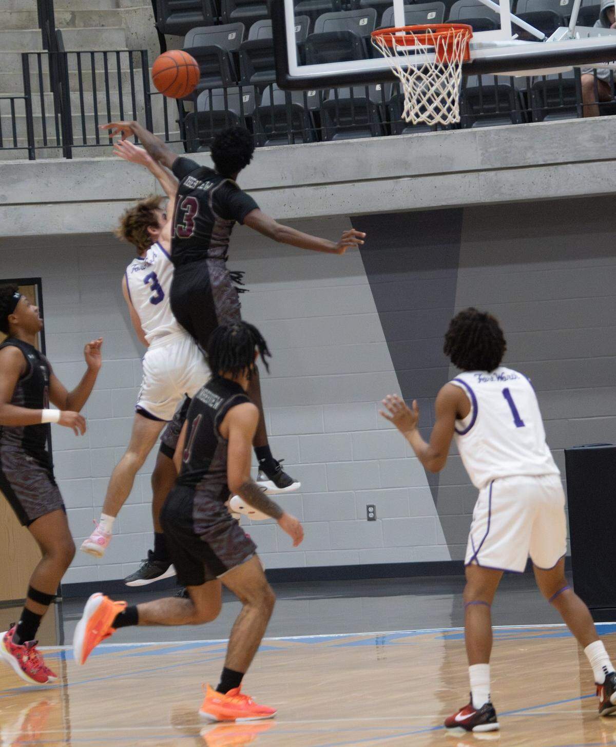 Mansfield Timberview’s B.J. Landers (13) goes up high to block the shot of Fort Worth Paschal’s Chris Debenport (3) in a Class 5A Division 1 bi-district game on Tuesday, February 18, 2025 at the Arlington ISD Athletics Center in Arlington, Texas. Timberview defeated Paschal 62-39.