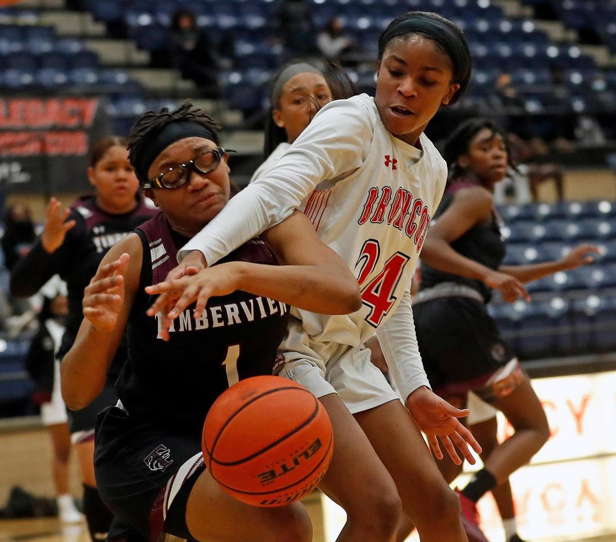 Timberview guard Tamalya Mims (1) and Legacy guard Eryn Scott (24) battle for the ball under Legacy’s net in the first half of a 8-5A district high school girls basketball game at Legacy High School in Mansfield, Texas, Friday, Jan. 22, 2021. The Lady Broncos led the Lady Wolves 22-11 at the half. (Special to the Star-Telegram Bob Booth)