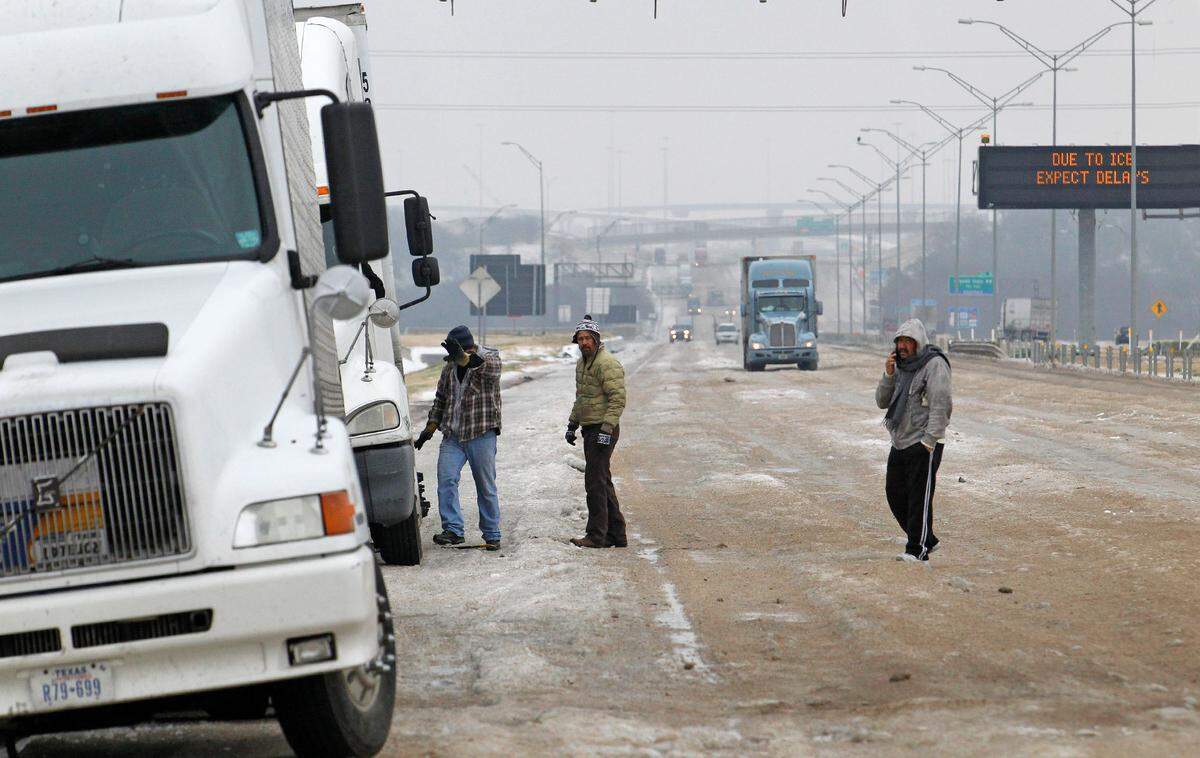 Dec. 8, 2013: Truckers Santos Ortiz and Alonso Medina try to help a fellow trucker get his rig moving on the shoulder of I-20 in Benbrook.
