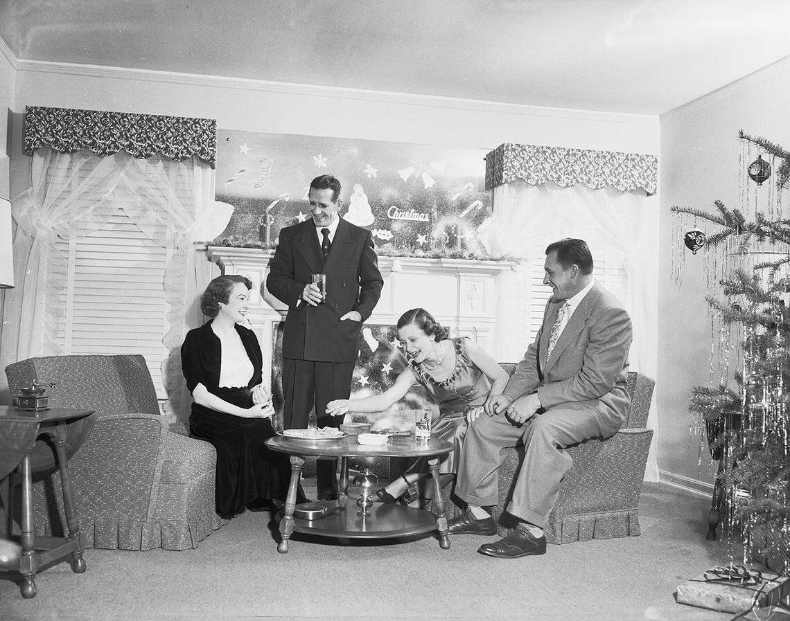 Dec. 26, 1952: Society series on holiday festivities. Fireside Tidbits: Mr. and Mrs. Don Willoughby, right, and Mr. and Mrs. Lewis Watkins.