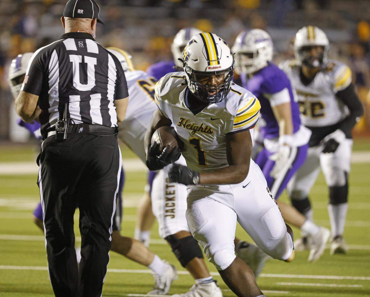 Arlington Heights running back Carson James (1) carries up the middle during the first half of a UIL football game between Arlington Heights and Paschal at Farrington Field in Fort Worth, Texas, Friday Nov. 07, 2025.