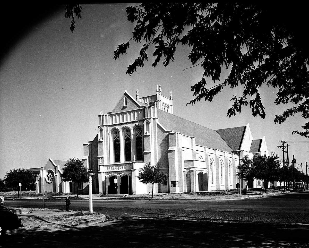 A view of Polytechnic Methodist Church from a street corner across an intersection. The church has several stained glass cathedral windows.