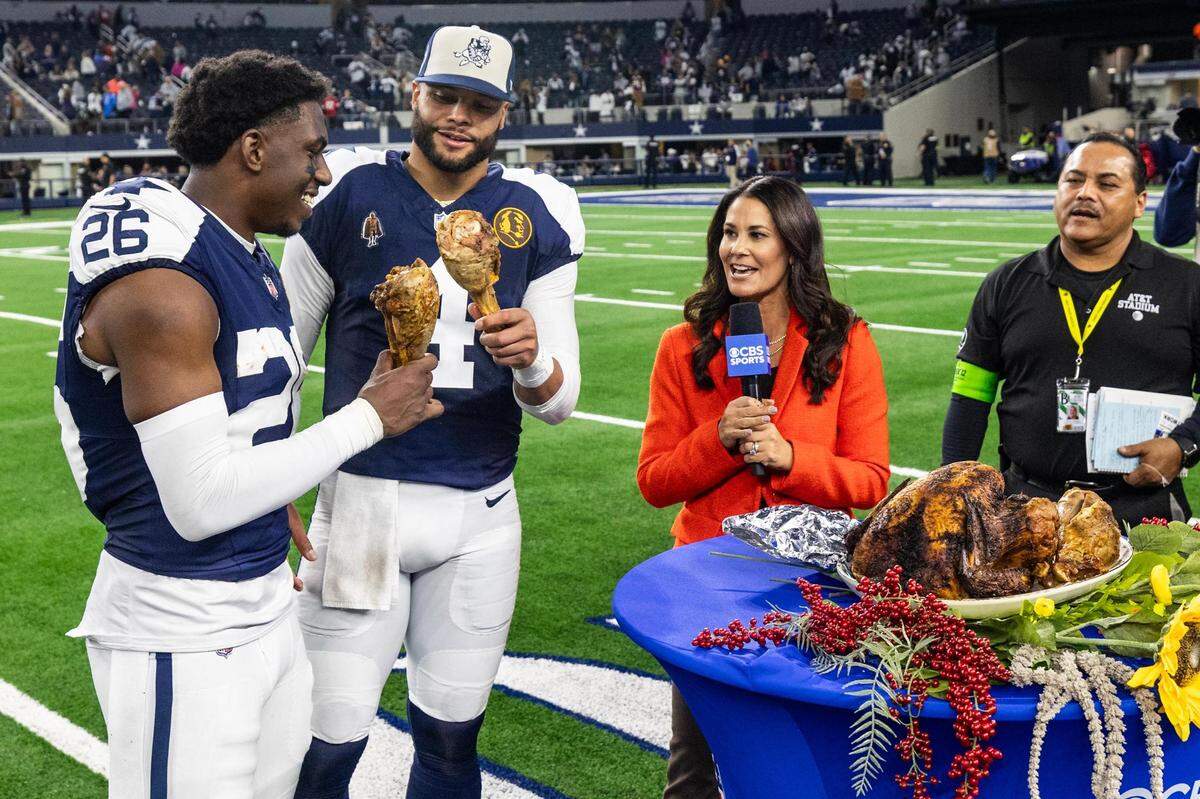Dallas Cowboys cornerback DaRon Bland (26) and quarterback Dan Prescott (4) cheers their postgame turkey legs after winning the Thanksgiving NFL game against the Washington Commanders at AT&T Stadium in Arlington on Thursday, Nov. 23, 2023. The Cowboys won 45-10.