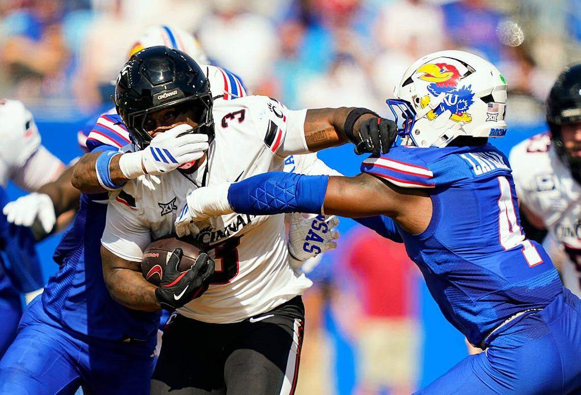LAWRENCE, KANSAS - SEPTEMBER 27: Tawee Walker #3 of the Cincinnati Bearcats runs the ball against Lyrik Rawls #2 and Trey Lathan #4 of the Kansas Jayhawks during the first half at David Booth Kansas Memorial Stadium on September 27, 2025 in Lawrence, Kansas. (Photo by Jay Biggerstaff/Getty Images)