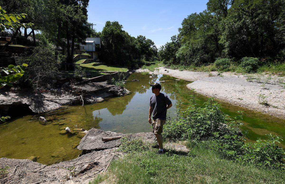 Sean Moore stands in the backyard of home that fronts Mary's Creek in Benbrook on Wednesday, July 30, 2025. Residents are concerned rezoning an 80-acre plot of land on the eastern edge of Mary's Creek for development could alter the floodplain and potentially cause seious flooding issues.