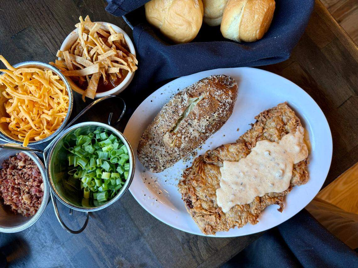 A chicken-fried steak at Cattlemen’s Steak House with a baked potato, toppings (left) and tortilla soup, top, in Fort Worth on Oct. 19, 2024.
