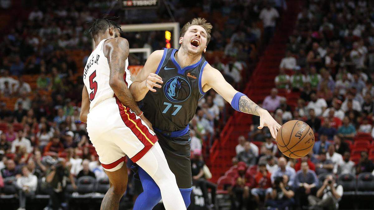 Dallas Mavericks forward Luka Doncic (77) is fouled by Miami Heat forward Derrick Jones Jr. (5) as he drives to the basket during the first half of an NBA basketball game, Thursday, March 28, 2019, in Miami. (AP Photo/Joel Auerbach)