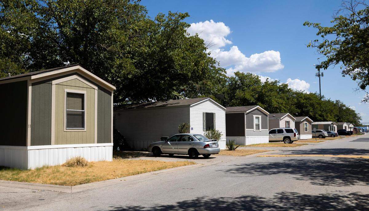 In Summit Oaks Homes in Fort Worth, rows of manufactured homes with porches and yards line the street.