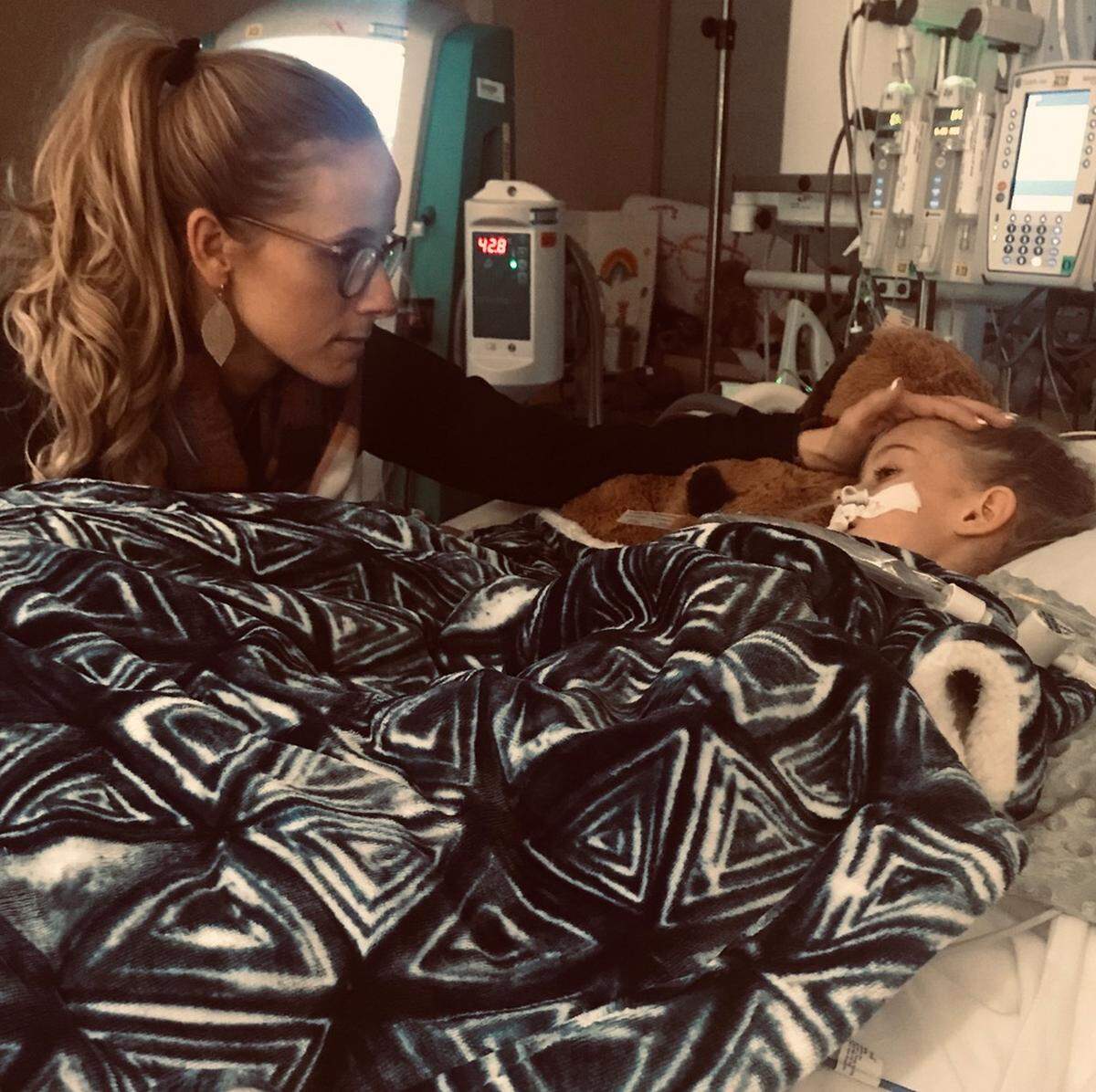 Lisa Robinson (left) comforts her daughter, Riley Robinson (right), during her hospital stay. Riley received a new heart last May after waiting for around seven months.