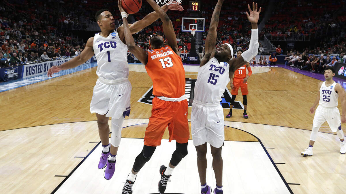 Syracuse center Paschal Chukwu (13) drives on TCU guard Desmond Bane (1) and JD Miller (15) during the first half of an NCAA men's college basketball tournament first-round game in Detroit, Friday, March 16, 2018.