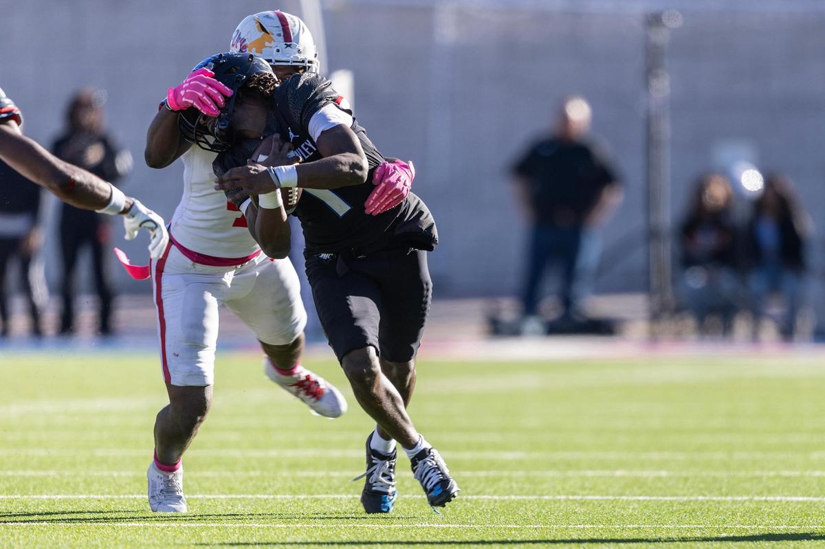 Duncanville linebacker Nehemiah Borner (4) grabs the face mask of North Crowley running back Cornelius Warren (1) on a tackle in the first half of the Class 6A Division I state semifinal game at Eagle Stadium in Allen on Saturday, Dec. 14, 2024.