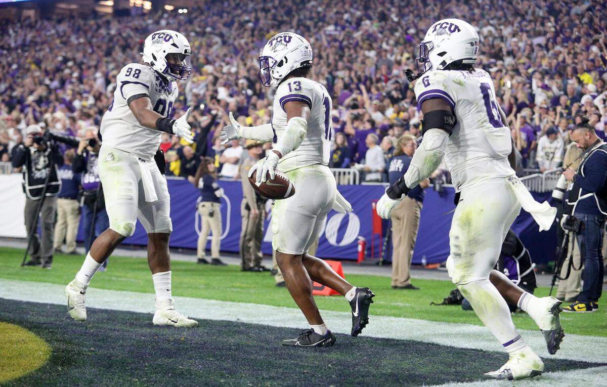 TCU linebacker Dee Winters, center, celebrates with teammates after running an interception in for a touchdown at the Vrbo Fiesta Bowl at State Farm Stadium in Glendale, Ariz., on Saturday, December 31, 2022.