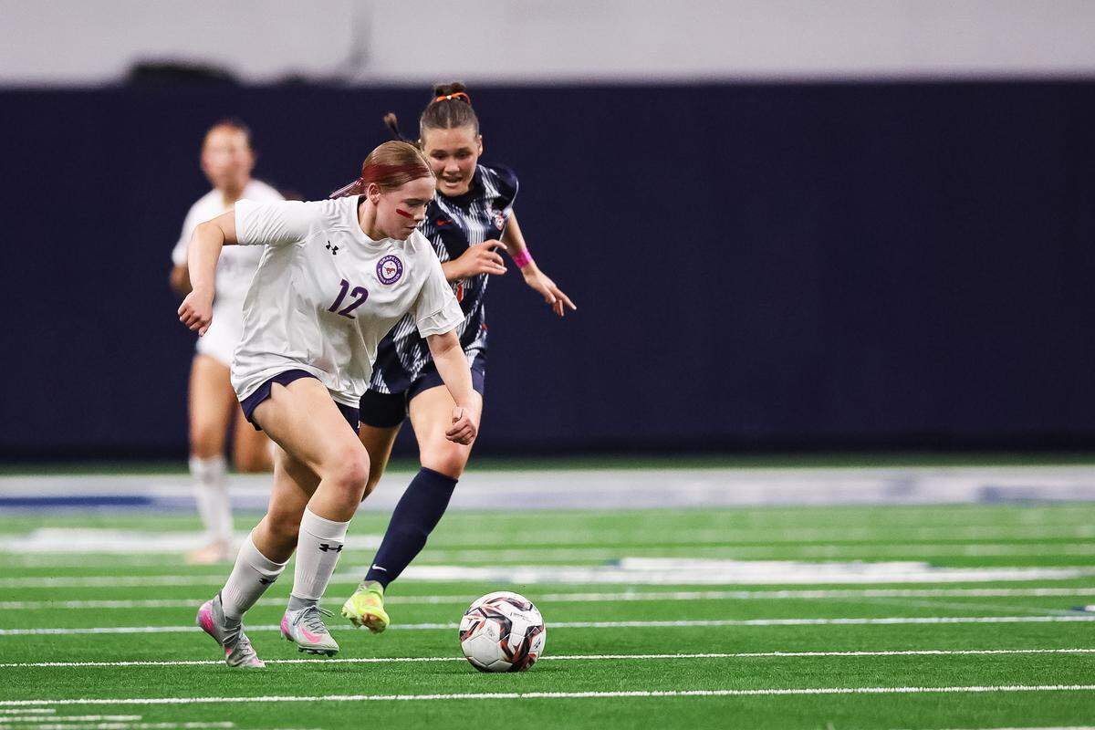 Grapevine forward Eleanor Batik (12) dribbles the ball past a Frisco Wakeland defender in a Class 5A Division II UIL girls soccer state semifinal at the Ford Center on April 3, 2026 in Frisco, Texas.