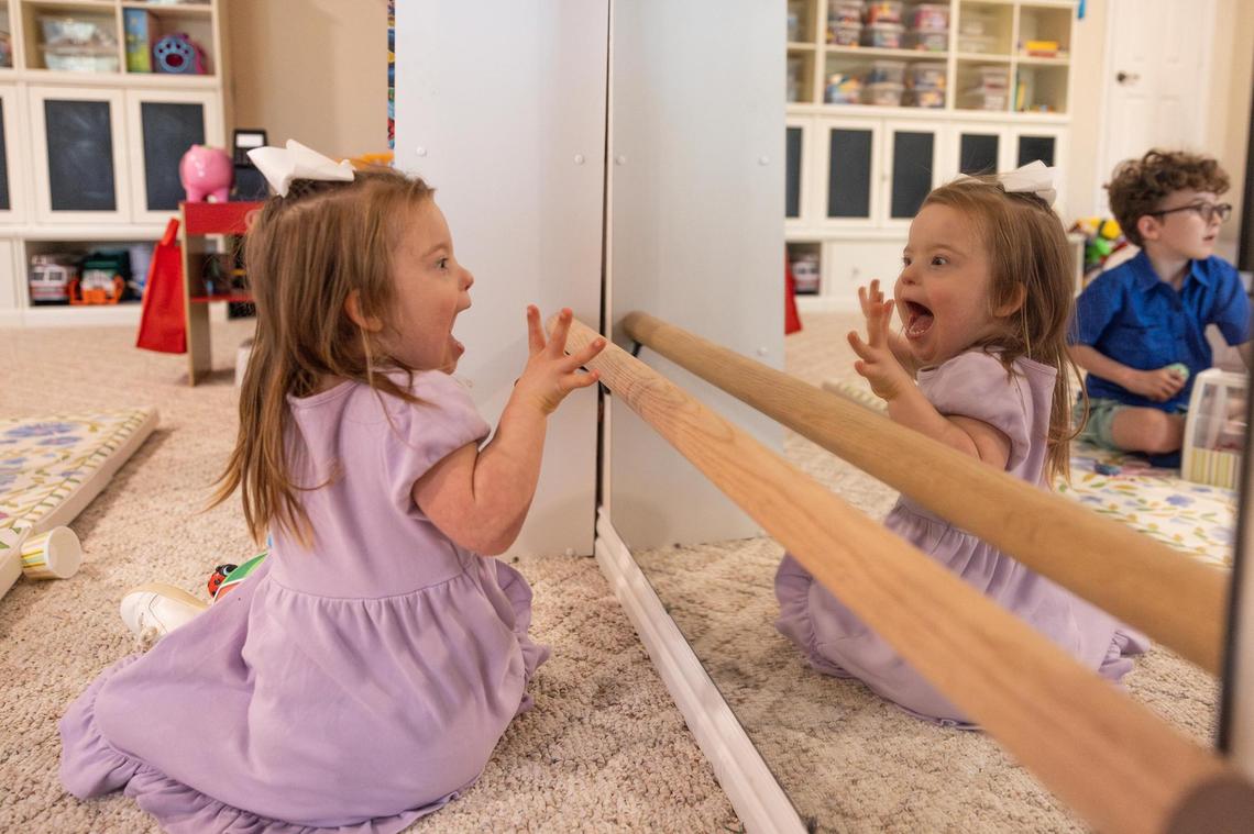 Annie Morey, 4, makes faces to herself in the mirror in the upstairs play room of her family’s home in Parker County on Friday, March 28.