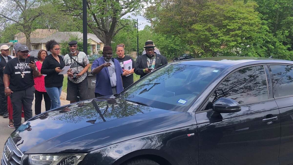 Residents look on as Brian Dixon, candidate for the District 4 Fort Worth school board seat, drives out of the residence he listed on his campaign filing. During a Thursday press conference outside of the home, allegations were made that Dixon doesn’t reside within the district he’s running in.