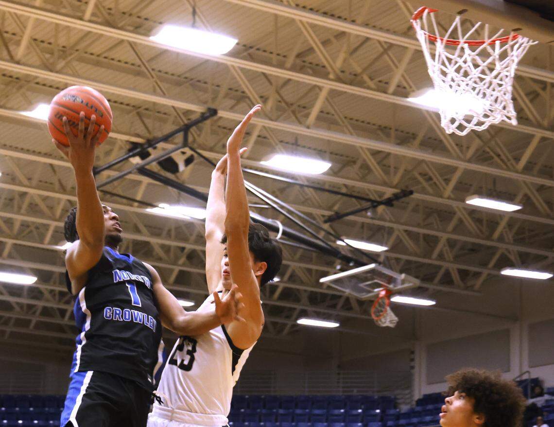 North Crowley shooting forward Alex Barther (1) gets two over the defense of Mansfield's Caden Shaver (23) during the first half of a UIL boys basketball game between North Crowley and Mansfield at Mansfield High School in Mansfield, Texas, Tuesday Jan. 20, 2026