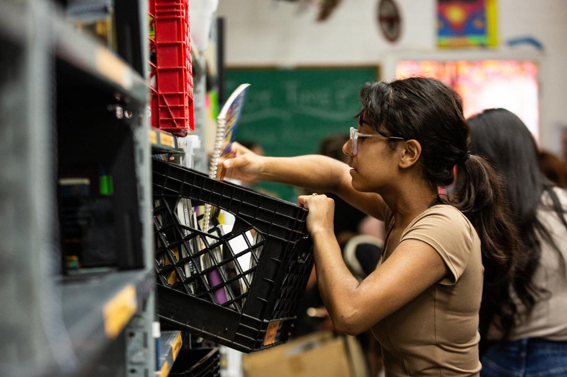 Sixth-grade teacher Cecille Lopez sifts through books and spiral notebooks on July 23, 2024. Lopez is a social studies teacher in Mesquite and was searching for world maps to decorate her classroom.