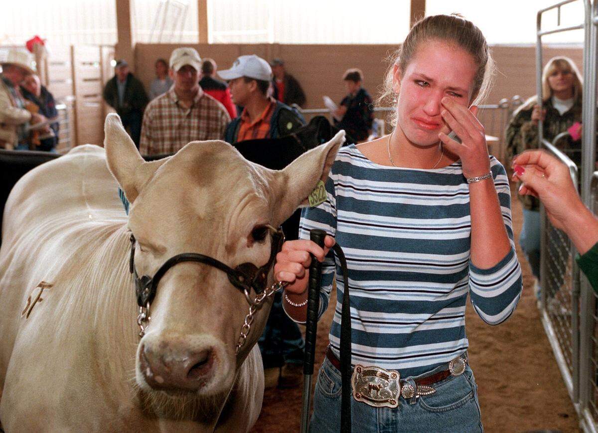 Oct. 6, 2000: Kayla Luensmann of Marion cries as she stands in line to lead her charolais named Casper to the auction block at the Tom Thumb Sale Pavilion at the State Fair of Texas in Dallas. Local and state FFA member youths bring the animals they have raised to the fair to be judged and sold at auction each year.