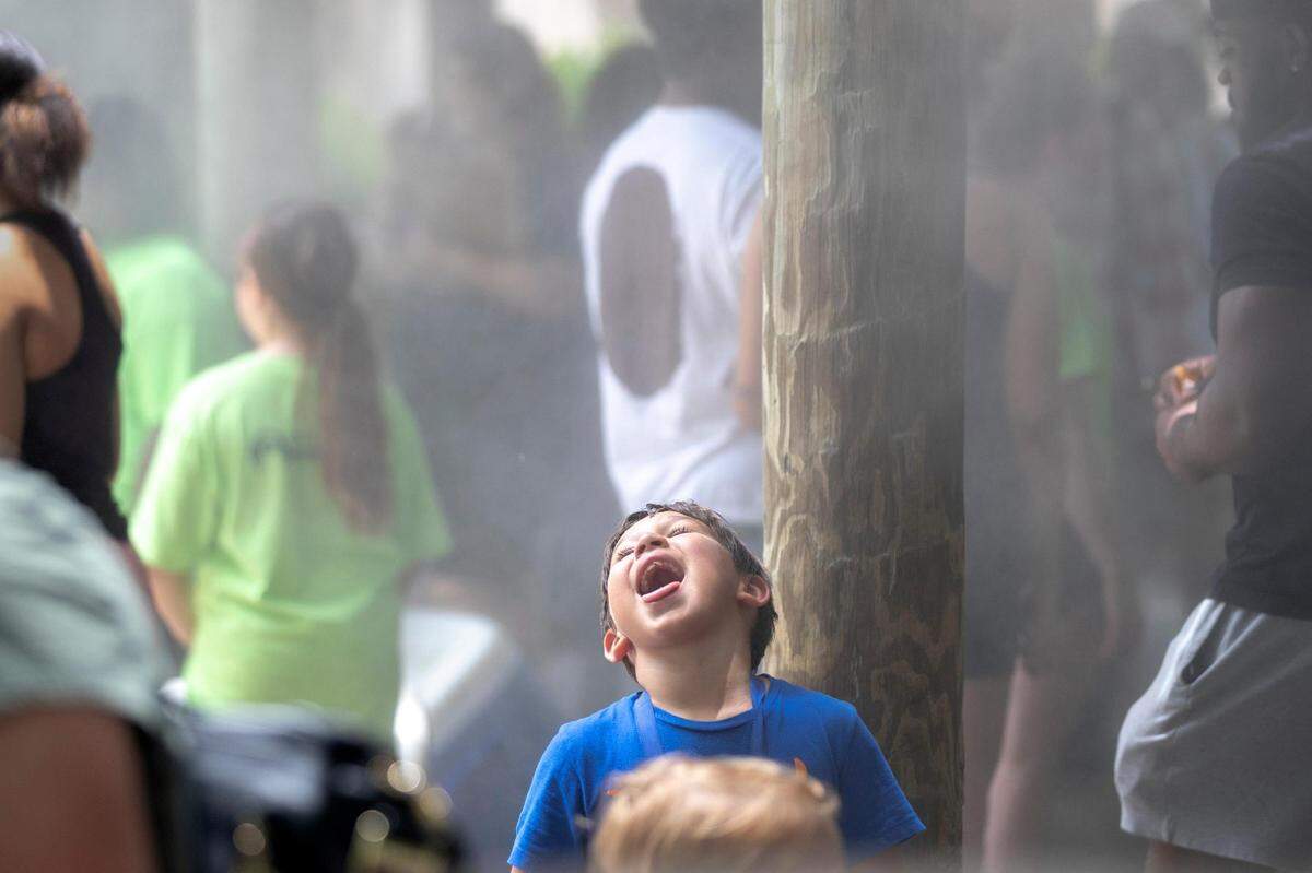Gael Jimenez, 7, from Caddo Mills, catches water on his tongue from misters at the Fort Worth Zoo on Wednesday, June 8, 2022.