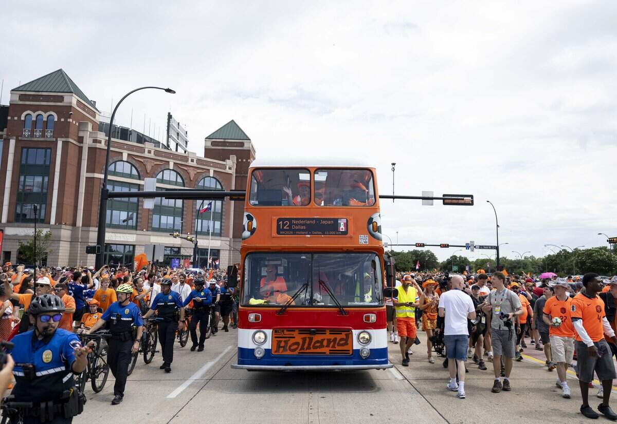 Netherlands soccer fans march to Dallas Stadium ahead of the FIFA World Cup match against Japan on Sunday, June 14, 2026 in Arlington, Texas. The famous double-decker Dutch Orange Bus, or De beroemde Oranjebus, is part of a Netherlands fan tradition bringing a sea of orange to the streets before major soccer matches.