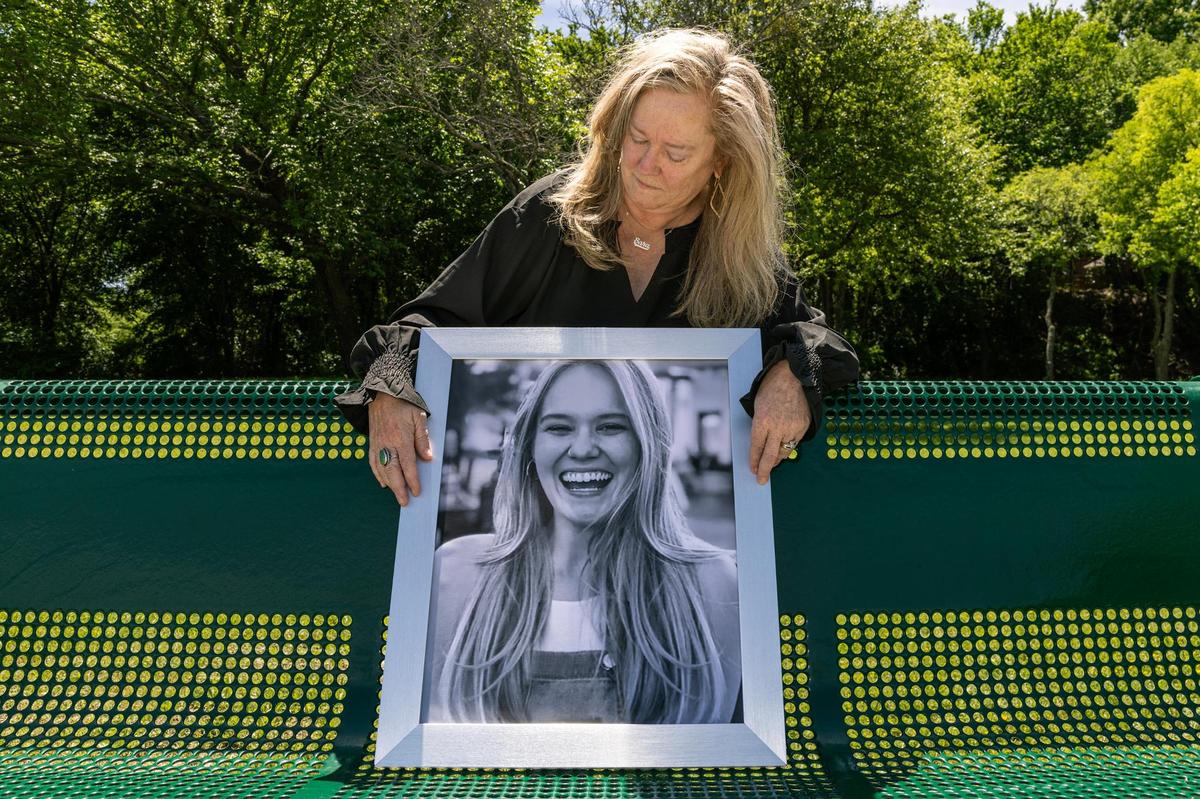 Fort Worth resident Tricia Hanson looks at a portrait of her daughter, Sara, on the memorial bench dedicated to her at Quail Ridge Park on April 11, 2024. Sara was shot to death in August 2020 by her boyfriend, Garrett Benson, in their hotel room in Bossier City, Louisiana.