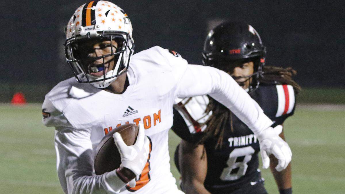 Haltom wide receiver Julian Johnson (8) outruns Trinity defensive back Shamar Morton (8) during the first half of a high school football game at Pennington Field in Bedford, Texas, Friday, Oct. 12, 2018. Haltom led 21-14 at the half. (Special to the Star-Telegram Bob Booth)

