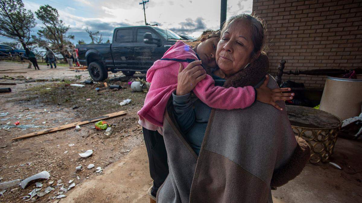 Bertha Gonzalez is comforted by her granddaughter Isa, two hours after a tornado ripped the roof of their house near Decatur on Dec. 13, 2022, while both were in the house getting ready for the day.