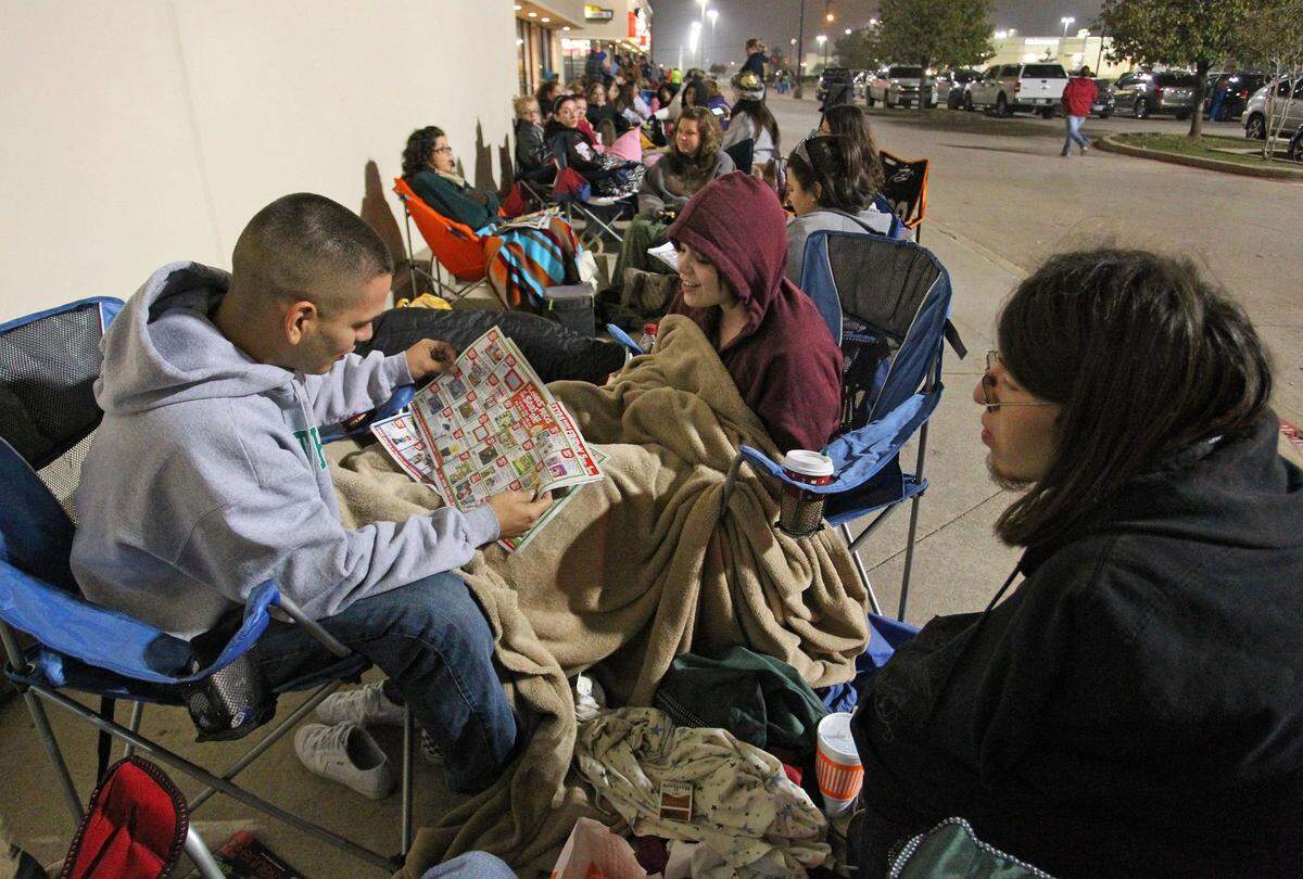2011: Anthony Lara holds a store pamphlet while waiting with friends Amber Branton and Josh Zamarripa in line about 3:30 p.m. at Toys R Us in Hurst.