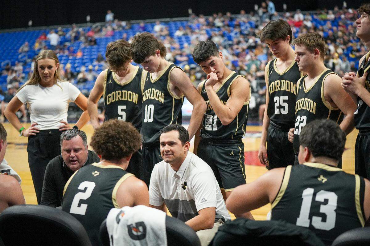 Gordon head coach Shad Reed (far left, kneeling) instructs his team during a time out against Benjamin in a Class 1A state semifinal on Thursday, March 7, 2024 at the Alamodome in San Antonio, Texas. Benjamin defeated Gordon 75-58.