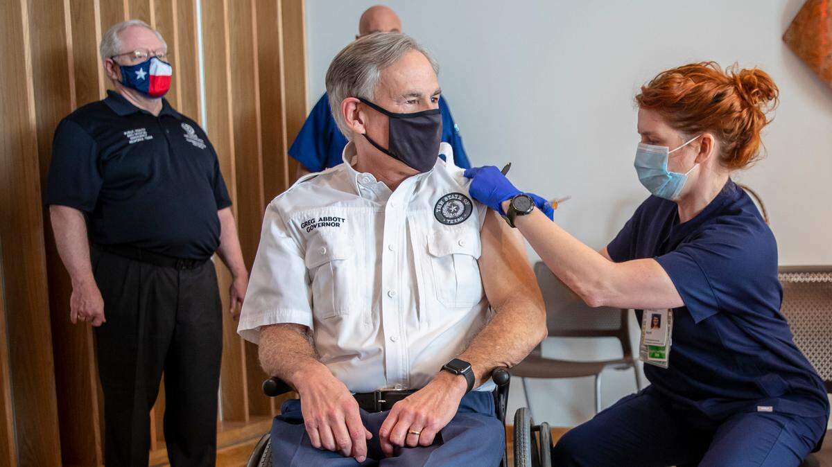 Registered nurse April Burgeons administers a dose of a Pfizer-BioNtech COVID-19 vaccine to Texas Gov. Greg Abbott at the Ascension Seton Medical Center on Tuesda. Commissioner Dr. John William Hellerstedt of the Texas Department of State Health Services far left and Registered nurse Toby Hatton looked on.