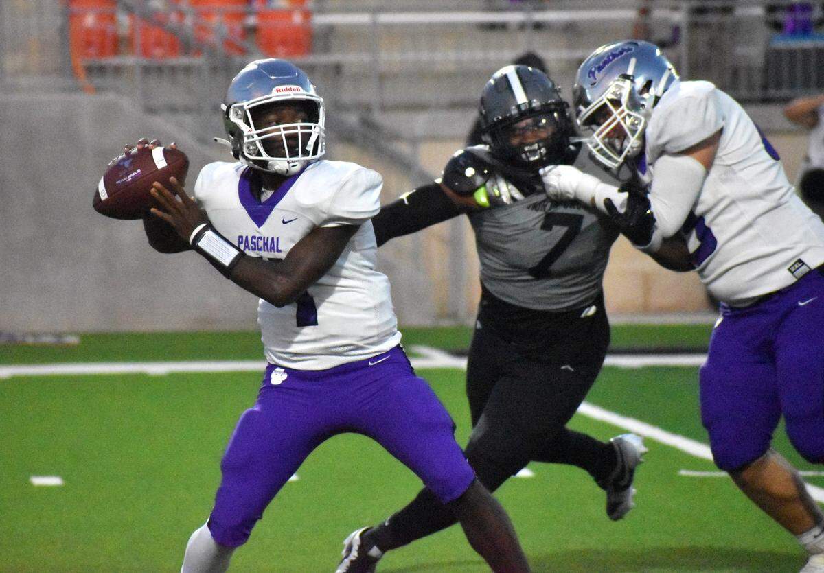Fort Worth Paschal’s Jashuan Thomas passes the ball while North Crowley’s Dacorien Thompson pursues him during Friday’s game at Crowley ISD Stadium.