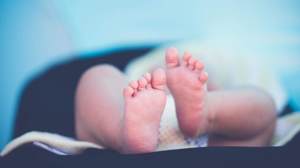 A newborn baby, not the one pictured, was found in bushes wrapped in a T-shirt, cops say.