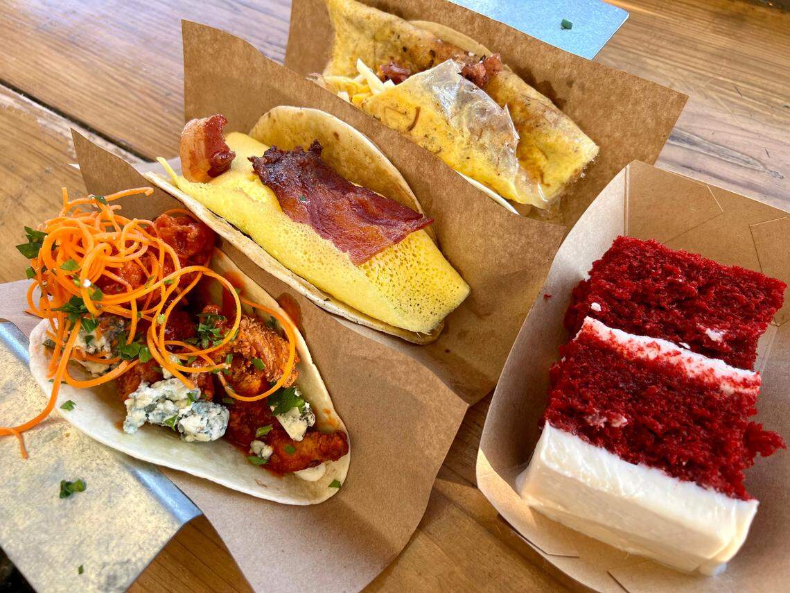A Buffalo chicken lunch taco, a bacon-egg-and-potato “French toast” breakfast taco and a bacon-brisket-and-pulled-pork breakfast taco at Velvet Taco Sept. 17, 2023, with the restaurant’s signature red velvet cake.