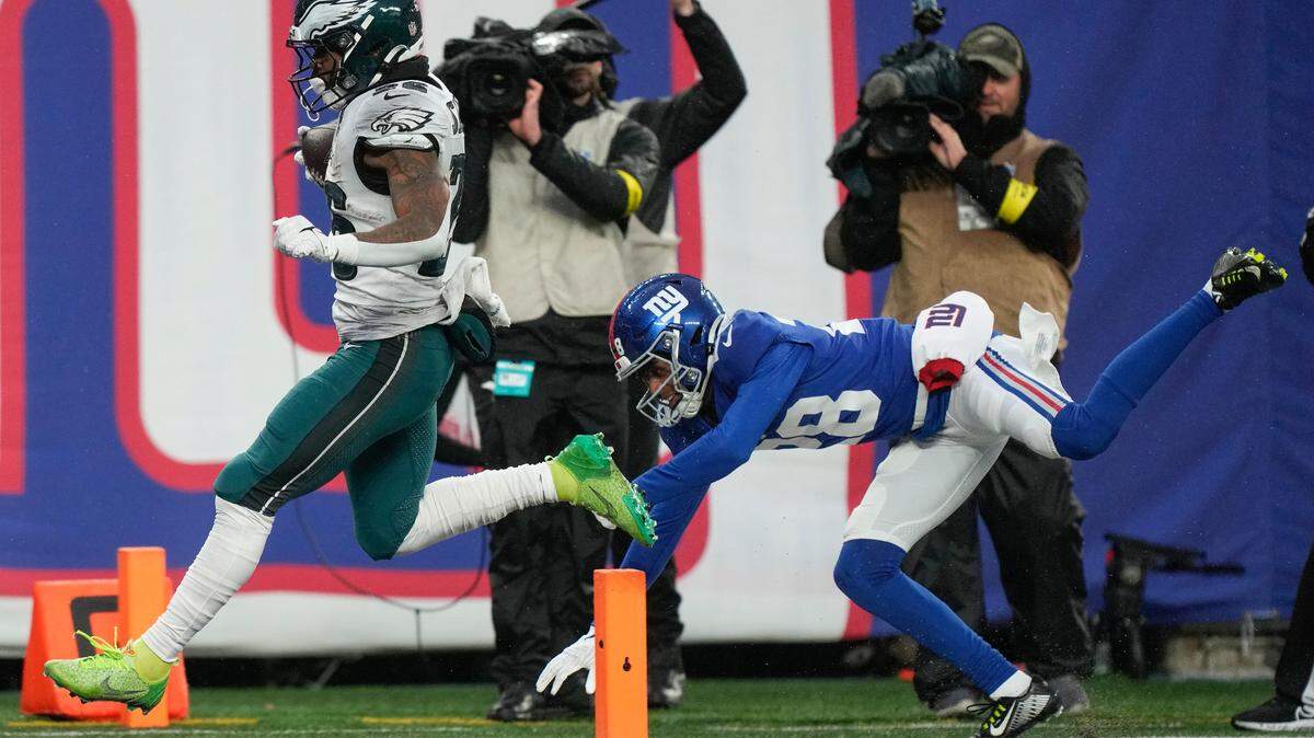 Philadelphia Eagles running back Miles Sanders (26) crosses the goal line as the New York Giants cornerback Cor’Dale Flott (28) tries to stop him on Sunday.