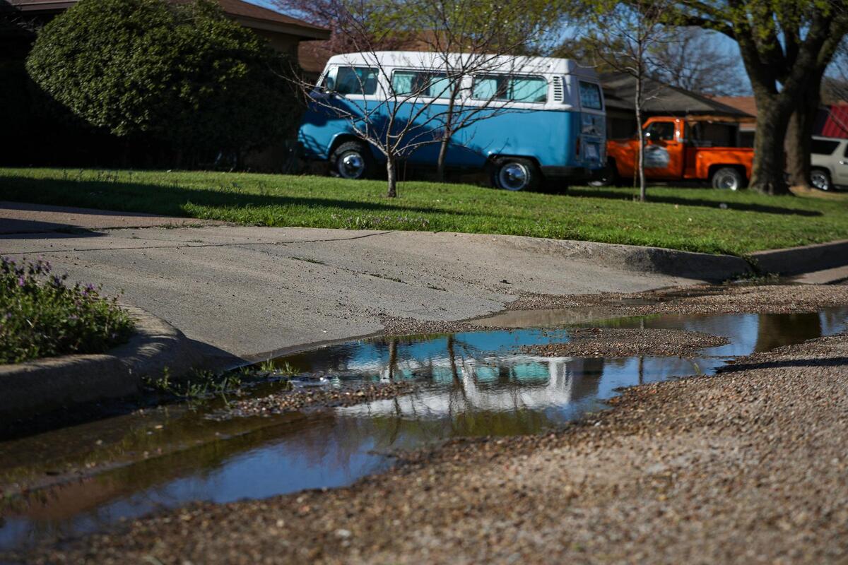 Puddles line the street in a neighborhood on Chambers Creek Drive in Everman, Texas, on Saturday, March 4, 2023. Flooding has been a continuous issue in the city just outside of Fort Worth.