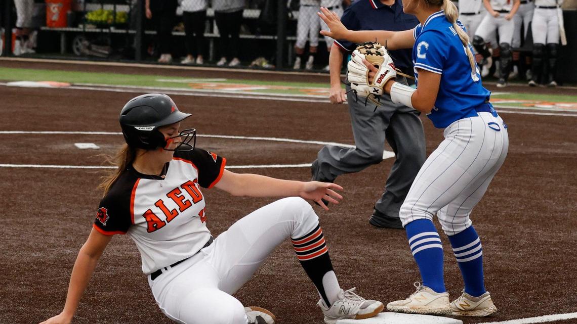 Centennial third baseman Hannah McCurry signals to hold the ball as Aledo third baseman Kyleigh Pawlak reaches third during the UIL Conference 5A Region 1 final softball game at Aledo, Texas, Wednesday, May 22, 2024.