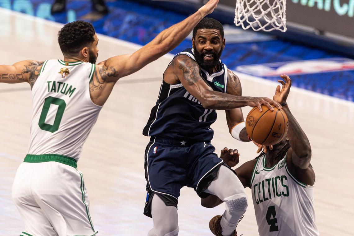 Dallas Mavericks guard Kyrie Irving (11) drives to the basket against Boston Celtics guards Jayson Tatum (0) and Jrue Holliday (4) in the fourth quarter of game 3 of the 2024 NBA Finals at American Airlines Center in Dallas on Wednesday, June 12, 2024.