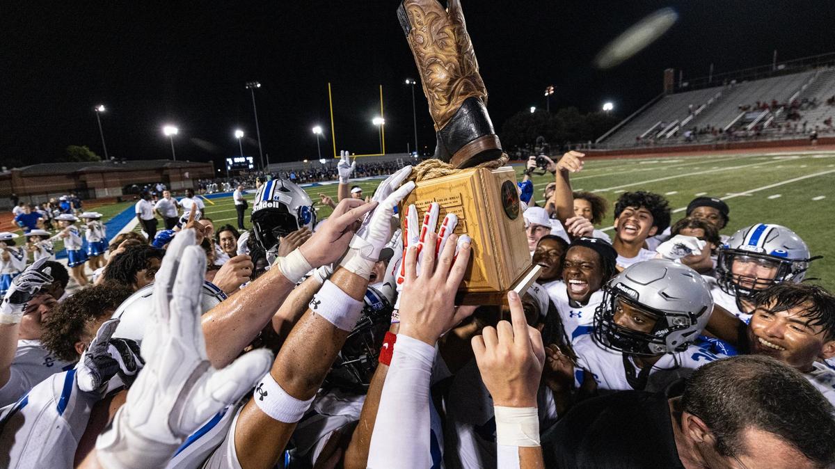 The Burleson Centennial Spartans football team hoists the Boot Bowl trophy after winning the 2024 Boot Bowl game against Burleson High School at BISD Stadium in Burleson on Friday, Aug. 30, 2024. The Spartans defeated the Elk 28-7 to take home the Boot Bowl trophy for the third year in a row.