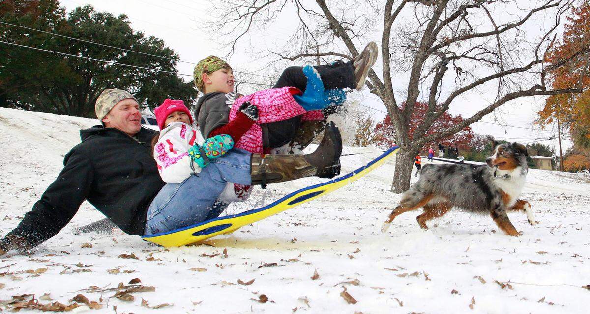 Dec. 8, 2013: Getting air off a ramp in Foster Park south of TCU, Landon Stallings rode with daughter Vada, 9, and son Jack, 8, as their dog Halo gives chase. Cold and ice remained in Fort Worth Sunday, with roads especially treacherous in the the morning hours before temperatures rose.