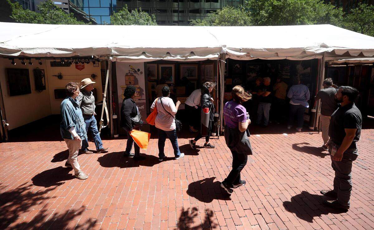 Visitors peruse some of the over 200 vendors at the Main Street Arts Festival on Friday, April 21, 2023 in downtown Fort Worth.