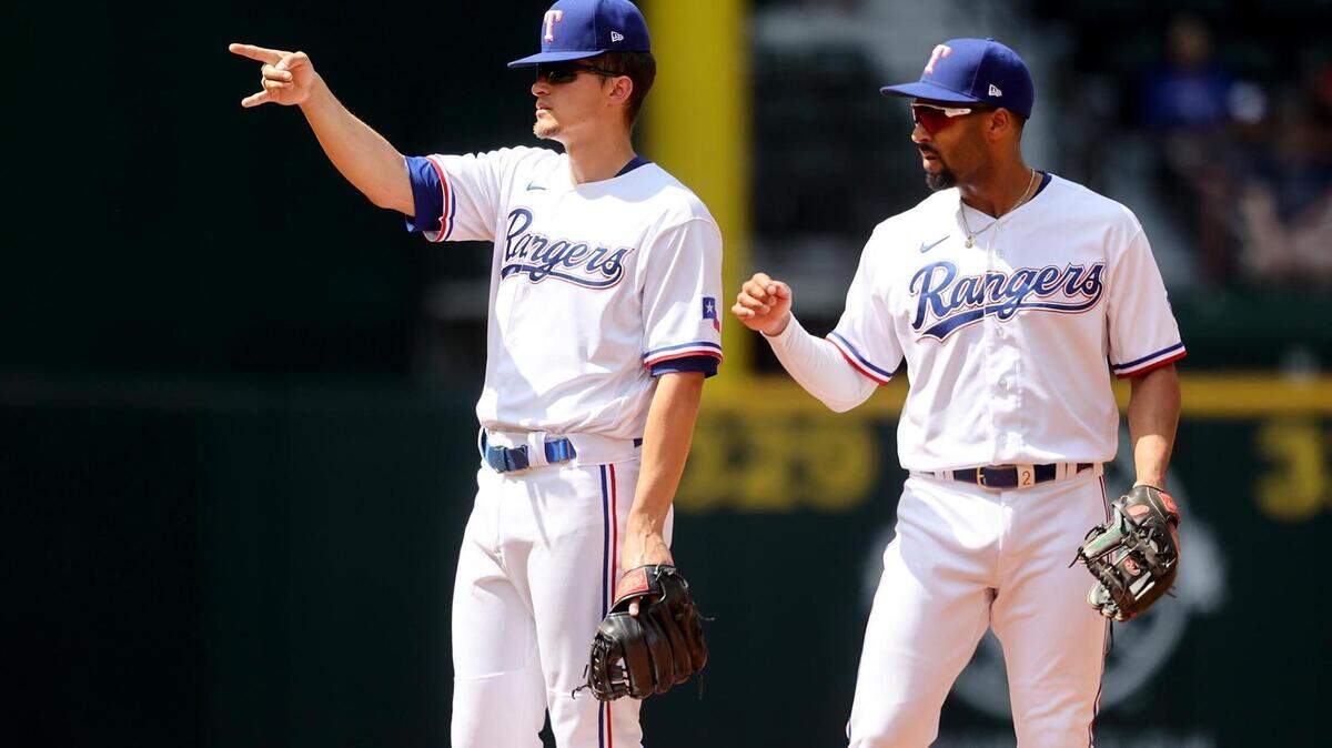 Texas Rangers shortstop Corey Seager, left, and second baseman Marcus Semien react after a close call against the Colorado Rockies on Monday, April 11, 2022, at Globe Life Field.