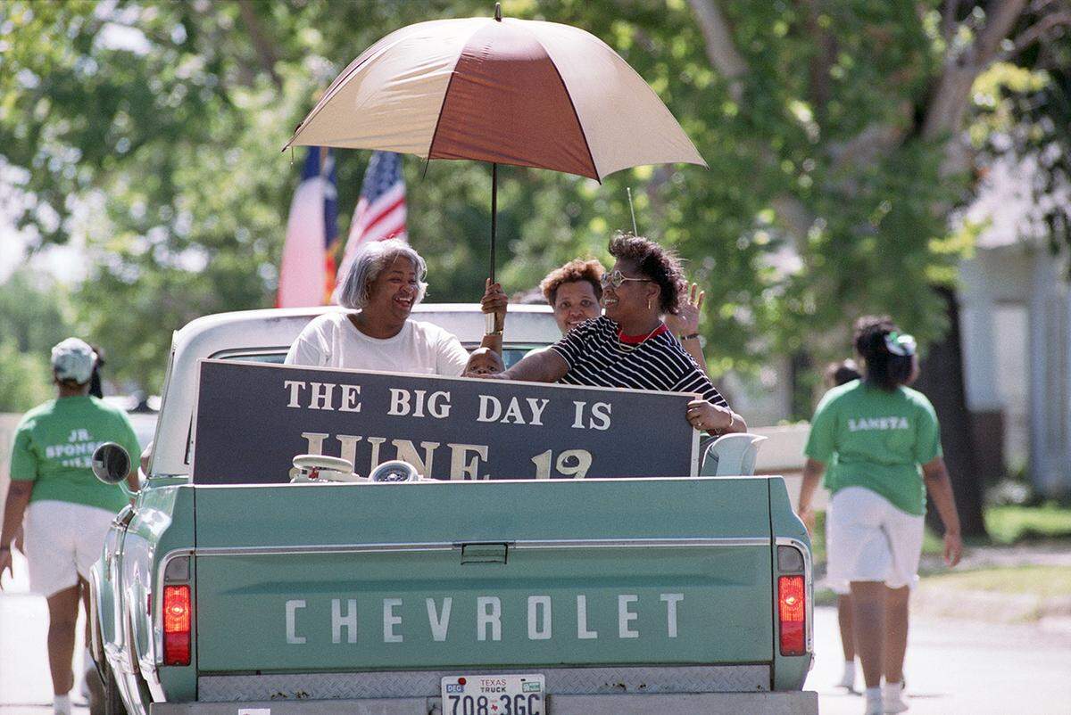 Pickup truck carrying people that was seen following the Junior Debutantes of Fort Worth in the Juneteenth parade. They are seen carrying the sign that reads “The Big Day is June 19.”	1990-06-16 [FWST photographer Jerry W. Hoefer]