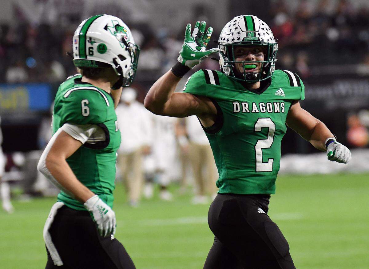 Southlake Carroll’s Owen Allen, right, high-fives teammate Landon Samson after a two-yard touchdown run to take a 27-0 lead over Midland Legacy in the second quarter of their Class 6A Division 1 Area football game Saturday, November 20, 2021 at Globe Life Field in Arlington, Texas. Special/Bob Haynes
