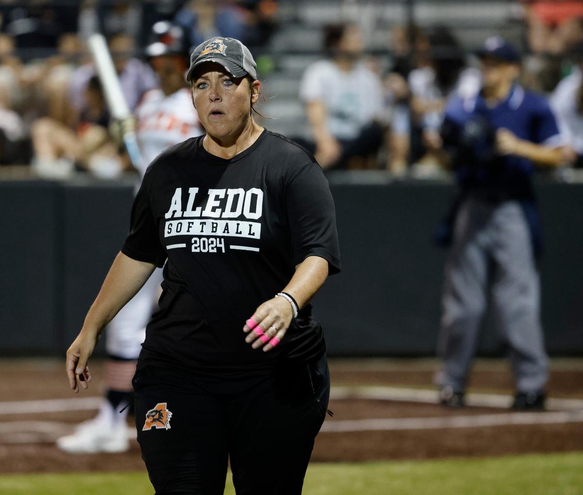 Aledo head coach Heather Myers heads to her third base position during the UIL Conference 5A Region 1 final softball game at Aledo, Texas, Wednesday, May 22, 2024.